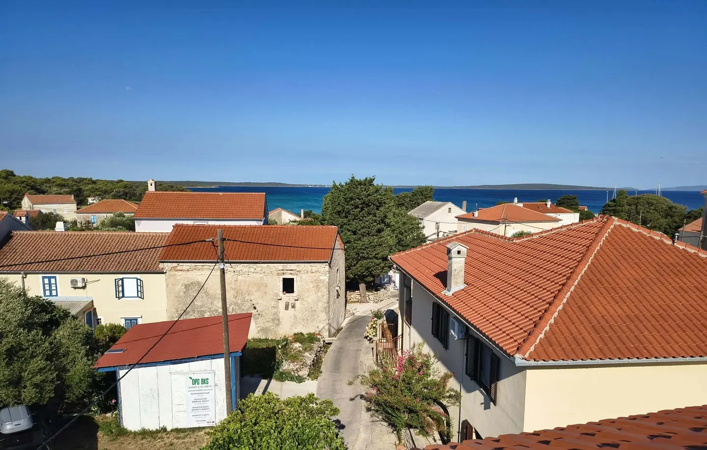 View over the red-tiled roofs of Olib village to the blue sea and the neighbouring islands